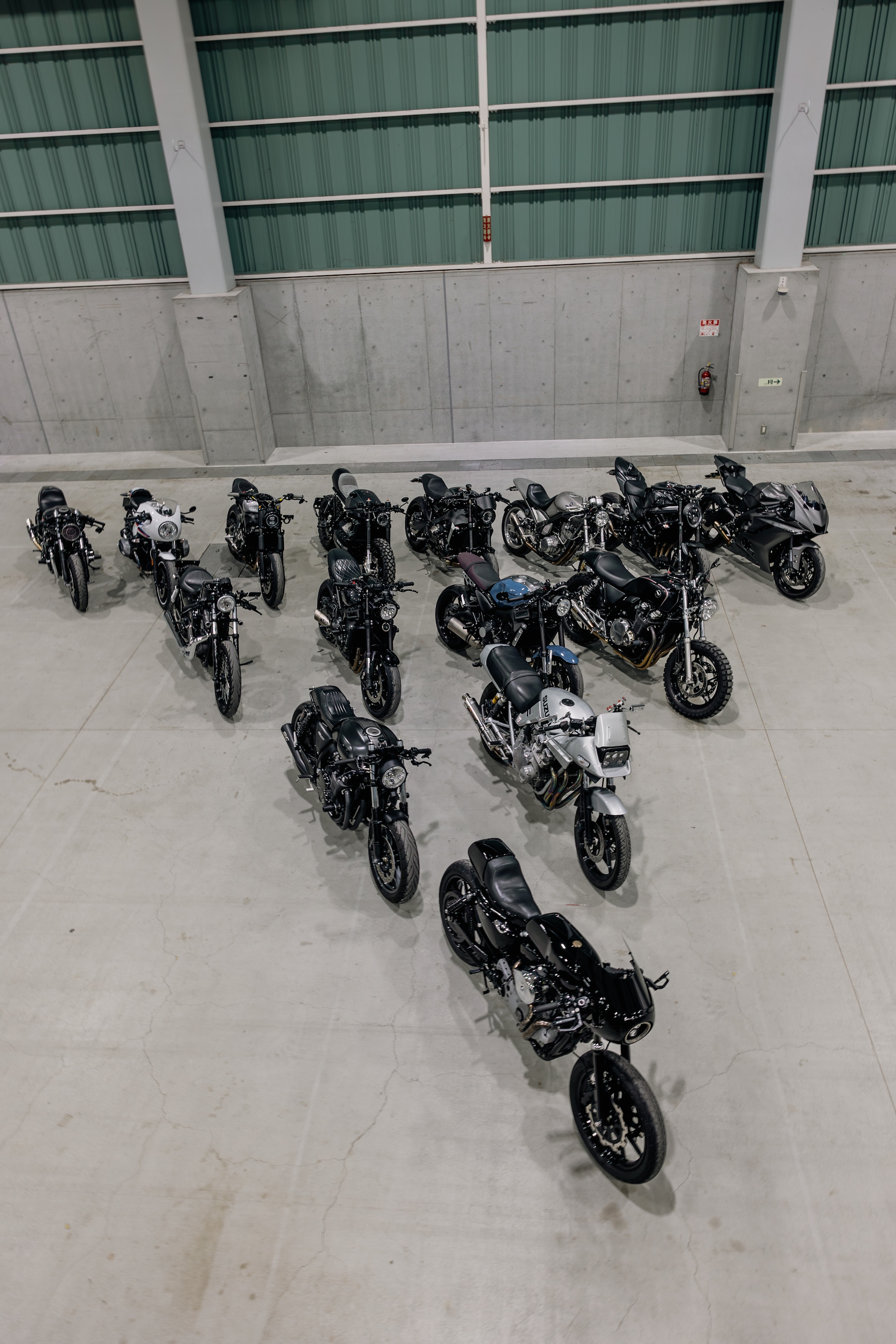 フロアに整列した黒基調のカスタムバイクを上から見下ろす