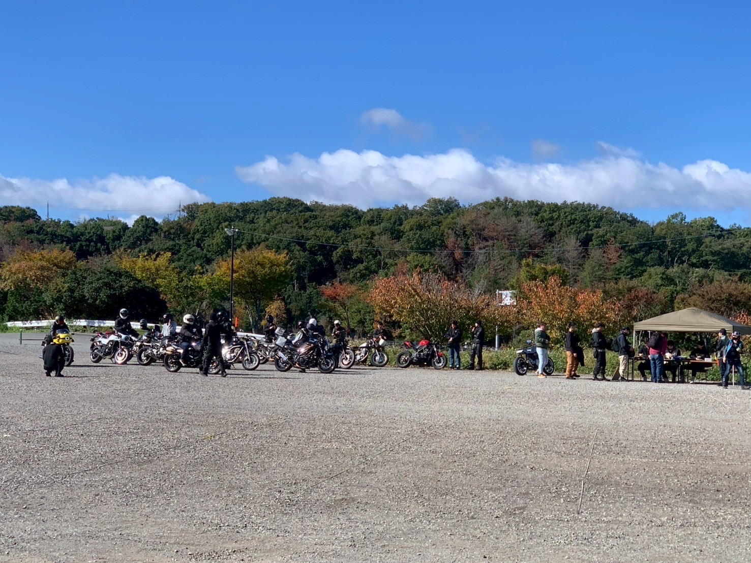 秋晴れの屋外エリアに並ぶバイクと受付テント